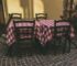 Cozy outdoor café setting with red checkered tablecloths in a rustic atmosphere. Ideal for dining concepts.